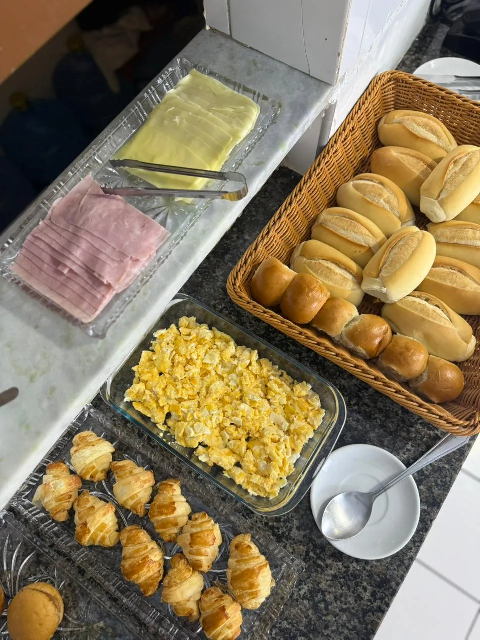 Bandejas com pães, sanduíches e bolos do café da manhã